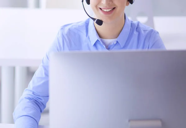 Ernstige mooie jonge vrouw die werkt als support telefoon operator met headset in het kantoor — Stockfoto