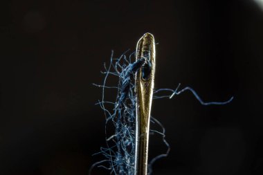 Bir iğnenin gözüne saplanmış mavi iplik