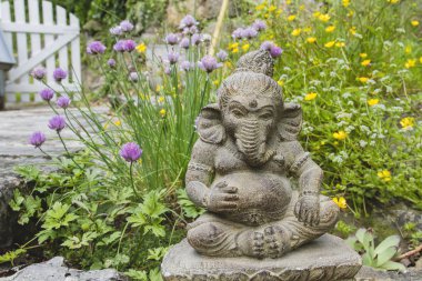 Bahar bahçesinde Ganesh taşı heykeli 