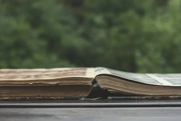 stock image old book open on a garden wooden table