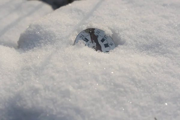 old pocket watch on the white snow