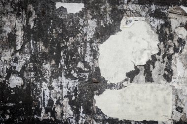 Kırık ilan panosu duvarında kağıt parçaları var.