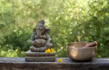 Sarı çiçekli ve Tibet kâseli Ganesha taş heykeli