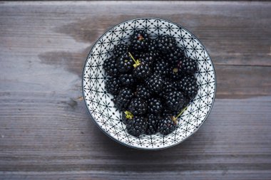 Tahta bir masada yaban mersinli kase