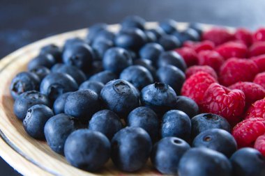 Taze yaban mersini ve ahududu kapayın.