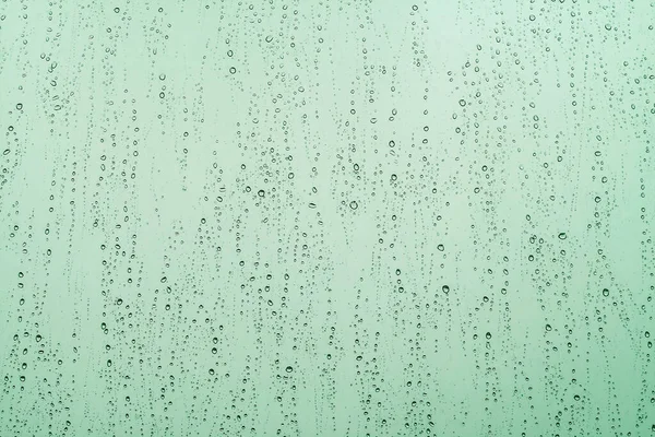 窓に雨が降り緑の抽象的な背景が — ストック写真