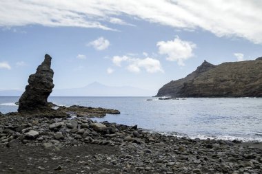 Hermigua, La Gomera, Kanarya Adaları, İspanya 'daki Playa la Caleta plajında kaya oluşumları ve Teide Dağı.