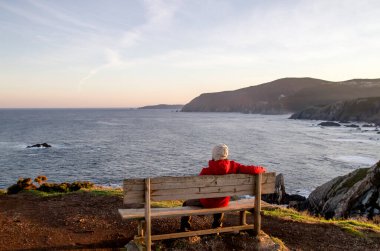 Lonely man sitting on a bench by the sea  clipart