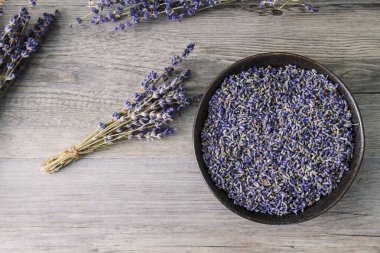 Kuru lavanta çiçekleri... ahşap masada buket ve kase. 