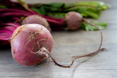 Raw red beetroots on wooden table  clipart