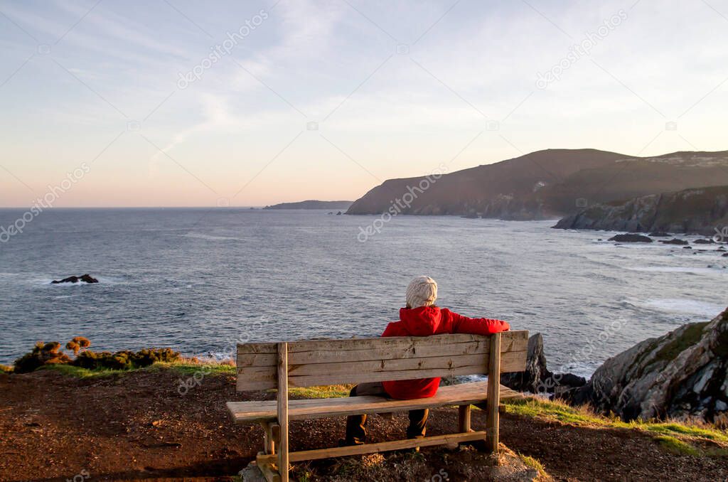 Lonely man sitting on a bench by the sea 