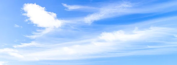 Blue sky with white clouds panoramic big shot. Background from the cloudy sky. Long and stretched clouds in the sky. Long cloud and one puffy. Blue sky with long clouds for background. Holobugo sky in blue with clouds for design