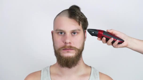 Hårklippta skalliga klippare. Den skäggiga mannen ser ut medan han skär. — Stockvideo