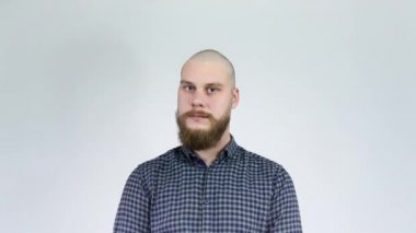 Sakallı bir adam ve aynada kel kafasına bakıyor..