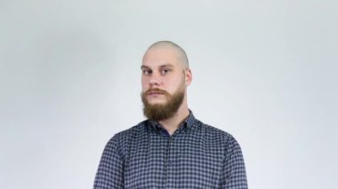 Çalı sakallı kel adam saçını göstererek başını çeviriyor.