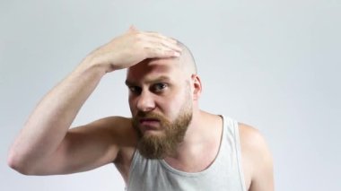 Genç bir adam kel saçsız kafamın yansımasını görüyor..