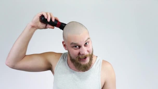 Egy szakállas férfi borotválja a fejét ollóval. Kopasz feje van a tükörben.. — Stock videók