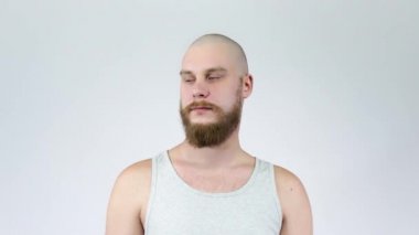Sakallı adam kel yüzünü ve profilini gösteriyor.