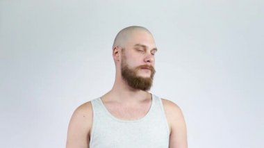 Sakallı kel adam kameraya dönüp gülüyor..