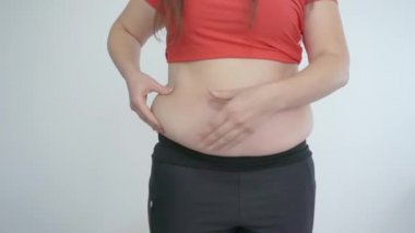 Kalın kız göbek yağına dokunuyor. Selülit ve obezite. Sabit video.