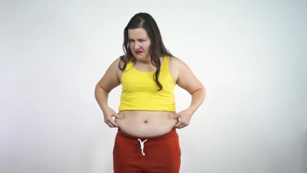 Gorda chica toca su vientre y agresivamente muestra mierda a la cámara — Vídeo de stock
