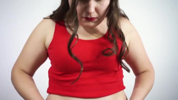 Dziewczyna płacze do kamery i patrzy na jego fałdy tłuszczu na brzuchu — Wideo stockowe