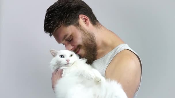 Il ragazzo barbuto sta tenendo il suo amato animale.Gatto preferito con occhi diversi . — Video Stock