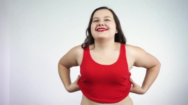Körper positives Konzept. Plump Dame zieht sich aus, schaut in die Kamera und lächelt — Stockvideo