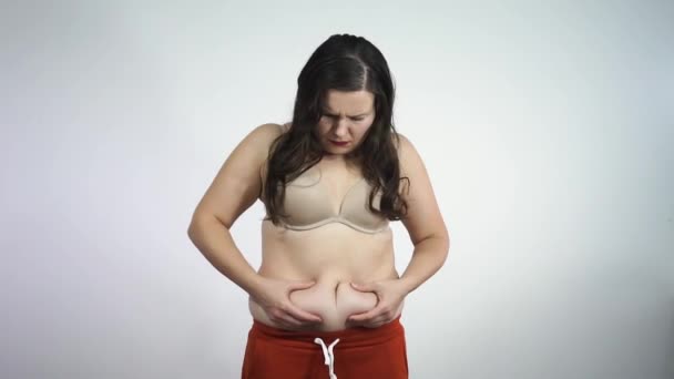 Chubby κορίτσι εξετάζει στην αντανάκλαση της περίσσειας λίπους κοιλιά σας — Αρχείο Βίντεο