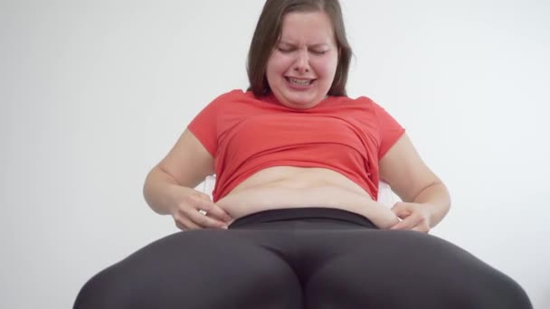 Gordura jovem considerando as dobras no estômago e chorando — Vídeo de Stock