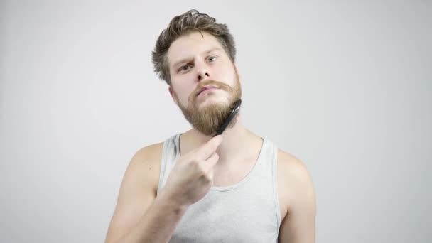 Le gars peignant sa barbe épaisse regardant dans le miroir — Video