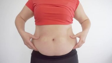 Kalın kız karnına dokunup kameraya doğru ağlıyor.