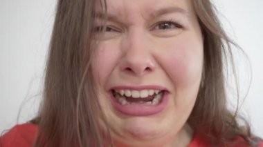 Kız kameraya doğru ağlıyor ve karnındaki yağ kıvrımlarına bakıyor.