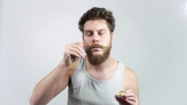 Воск для ухода за бородой. Мужчина кладет свои усы с воском. — стоковое видео
