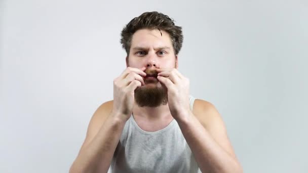 De man met de baard heeft zijn snor neergelegd. Thuiszorg voor een snor. — Stockvideo