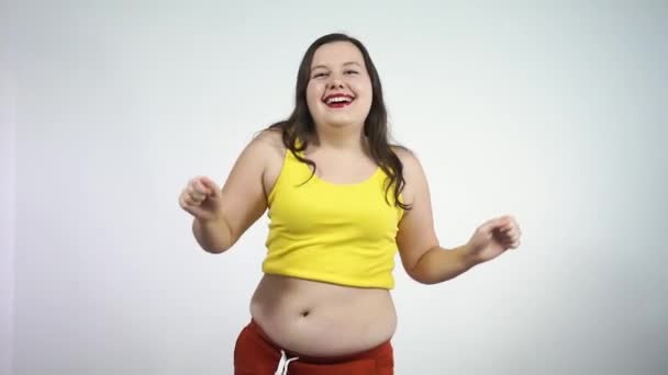 Corpo positivo.Uma garota grossa com uma barriga grande dançando provocativamente e sorrindo — Vídeo de Stock