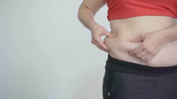 Chica gruesa toca la grasa del vientre. Celulitis y comer en exceso — Vídeos de Stock