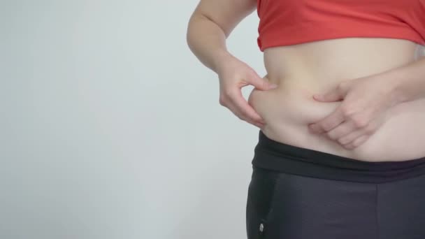 Een dik meisje raakt het buikvet aan. Cellulitis en overmatig eten — Stockvideo