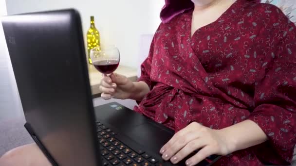 Девушка в маске пьет вино во время видеоконференции. Работа над изоляцией — стоковое видео