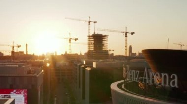 Berlin, Almanya 'daki Mercedes Benz arenasına doğru Alexanderplatz TV Kulesi ve Sunflairs ile güzel bir Sunset' te.