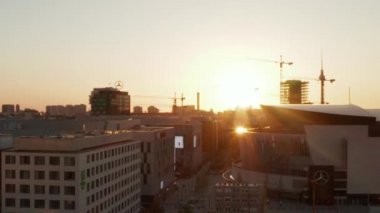 Berlin, Almanya 'daki Mercedes Benz arenasına doğru Alexanderplatz TV Kulesi ve Sunflairs ile güzel bir Sunset' te.