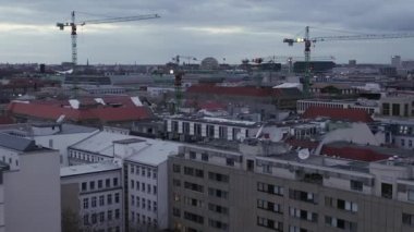 Günbatımında inşaat vinçleriyle Berlin Almanya 'nın merkezinde yavaşça uçuyor. 