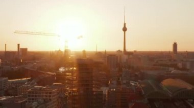 Berlin, Almanya şantiyesi güzel günbatımı, güneş ışığı ve Alexanderplatz TV Kulesi, Sunflairs manzaralı vinçler.