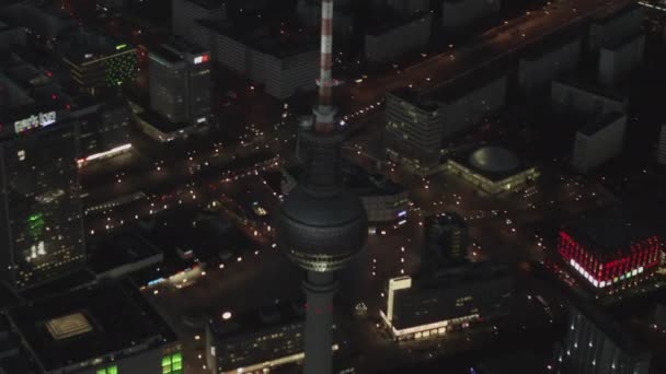 AERIAL: Nad Berlinem Niemcy Wieża telewizyjna Alexanderplatz nocą z oświetleniem miejskim — Wideo stockowe