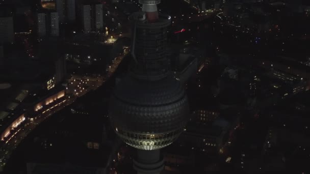 AERIAL: Close Up of Berlin Alemanha Torre de TV Alexanderplatz à noite com luzes da cidade tráfego — Vídeo de Stock