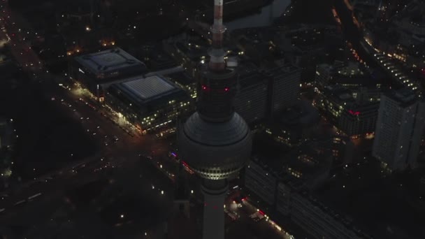 AERIAL: Sobre Berlim Alemanha Torre de TV Alexanderplatz à noite com luzes da cidade tráfego — Vídeo de Stock
