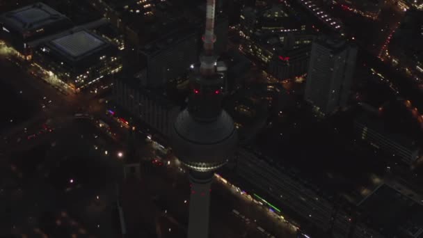AERIAL: Över Berlin Tyskland TV Tower Alexanderplatz på natten med City Lights trafik — Stockvideo