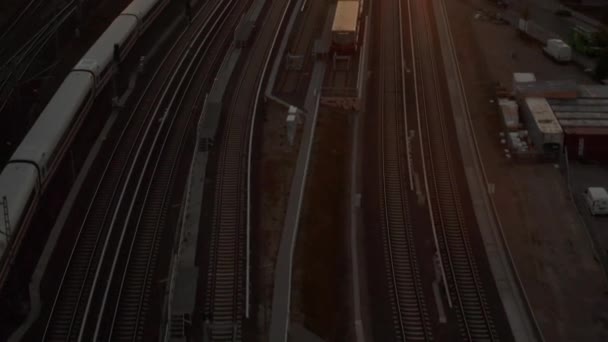 АЭРИАЛ: Полет над Берлином, Германия, Центральный железнодорожный вокзал с поездом ICE Train на красивом закате, солнечный свет и вид на телебашню Алексия, солнечные вспышки — стоковое видео