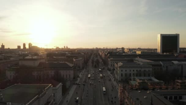 AERIAL: Scenic lage vlucht door drukke Berlijn, Duitsland Straat richting Brandenburger Tor in prachtige gouden zonsondergang licht — Stockvideo