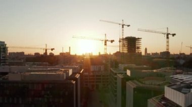 Berlin, Almanya şantiyesi güzel günbatımı, güneş ışığı ve Alexanderplatz TV Kulesi, Sunflairs manzaralı vinçler.